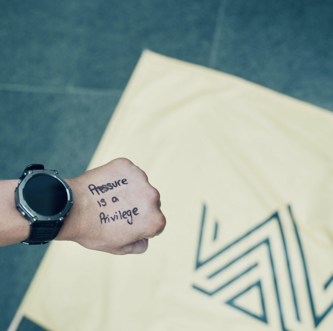 Pressure is a Privilege handwritten on the back of Line's hand before a race