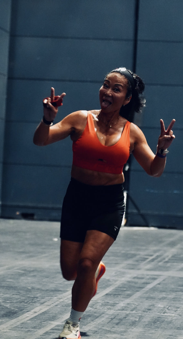 Line running across the arena floor mid-race, flashing peace signs